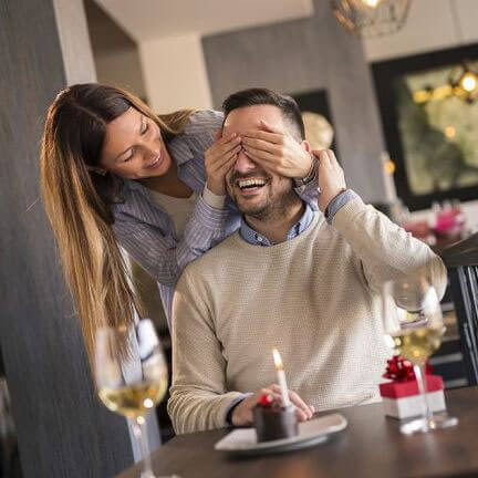 woman surprising man with gift